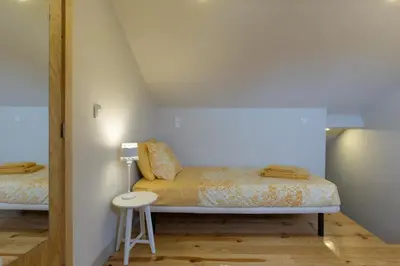 a small bedroom with a bed and a stool at Luz & Alegria Place! in Porto
