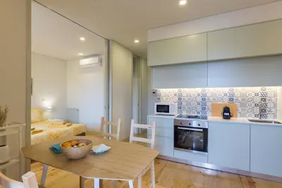 a kitchen and living room with a table and a dining room at Luz & Alegria Place! in Porto