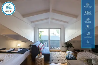 a living room with a bed and a large window at Beautiful Loft Downtown Porto in Porto