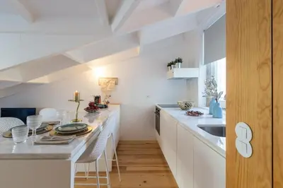 a kitchen with white cabinets and a counter with a sink at Beautiful Loft Downtown Porto in Porto