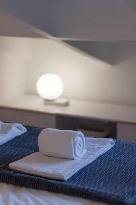 a stack of towels sitting on a bed at Beautiful Loft Downtown Porto in Porto