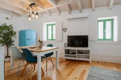 a dining room with a table and chairs and a tv at Lovely Nest Downtown Porto in Porto