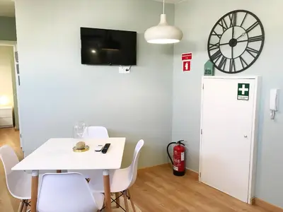 a dining room with a white table and chairs and a clock at Little Tower in Porto