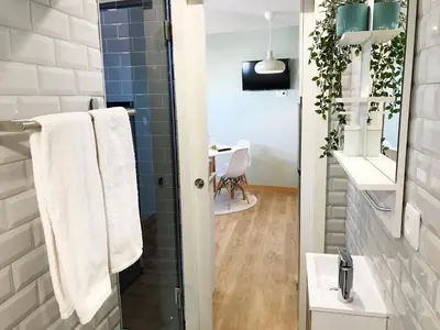 a bathroom with a shower with a sink and a mirror at Little Tower in Porto