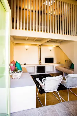 a living room with white chairs and a staircase at Estúdio 22 na Boavista, JAMBA House in Porto