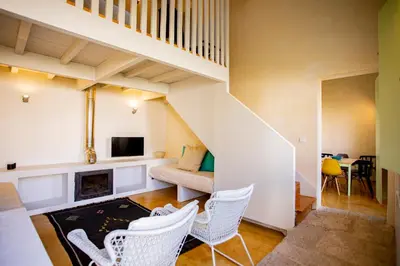 a living room with white chairs and a staircase at Estúdio 22 na Boavista, JAMBA House in Porto