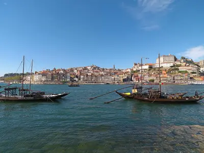 two boats sitting in the water near a city at FLH Oporto Wine Cellars Luxury Apartment II in Vila Nova de Gaia