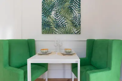 a table with two green chairs and a white table with two cups at Loureiro Villas in Porto