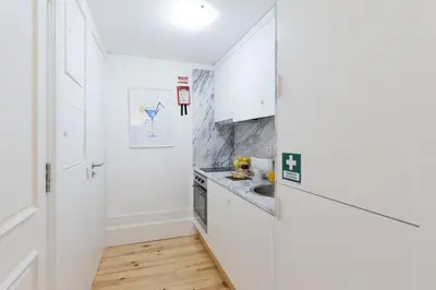 a kitchen with white cabinets and a sink at Loureiro Villas in Porto
