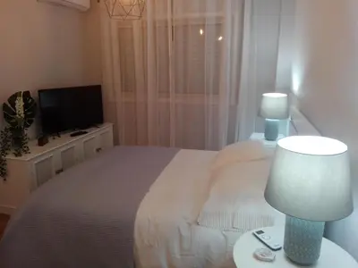 a bedroom with a bed with a lamp and a tv at Secondlove in Porto
