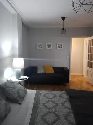 a bedroom with a bed and a couch and a lamp at Secondlove in Porto