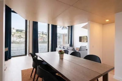 a dining room with a wooden table and chairs at Loft Douro Cais da Fontaínha in Vila Nova de Gaia