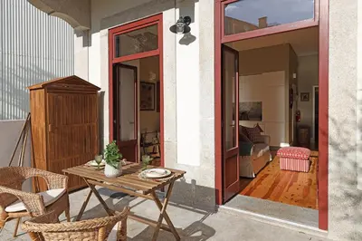 a patio with a table and chairs and a room at Oporto MyWish City Central Apartment with Private Garden in Porto