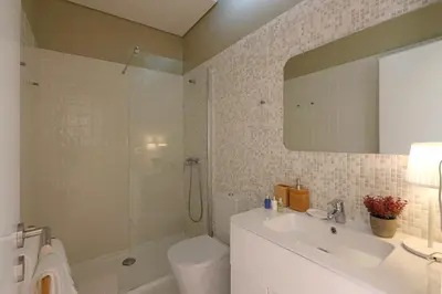 a bathroom with a sink and a toilet and a mirror at Oporto MyWish City Central Apartment with Private Garden in Porto