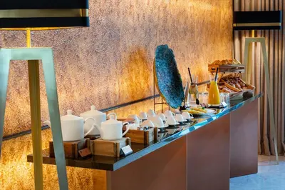 a buffet line with white dishes on a counter at BessaHotel Baixa in Porto