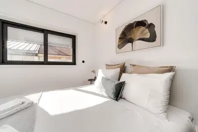 a bedroom with a white bed and a window at Nomad's Family - 2BED Spacious Apartment Gaia in Vila Nova de Gaia