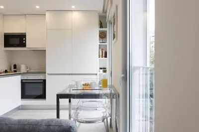a kitchen with a glass table and chairs at LovelyStay - Modern Loft with Gym & Free Parking minutes away from CBD in Porto