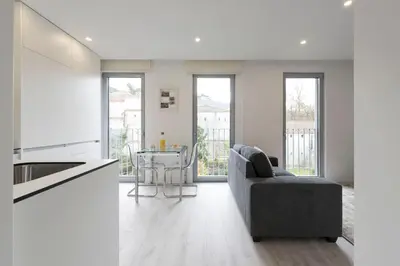 a kitchen and living room with a couch and a table at LovelyStay - Modern Loft with Gym & Free Parking minutes away from CBD in Porto