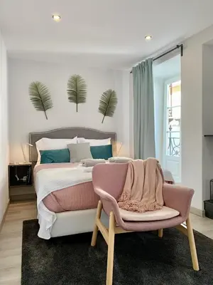a bedroom with a large bed and a chair at BF Suites & Apartments in Porto