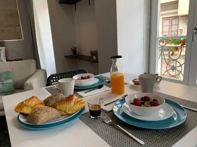 a table with two plates of food and a bowl of fruit at BF Suites & Apartments in Porto