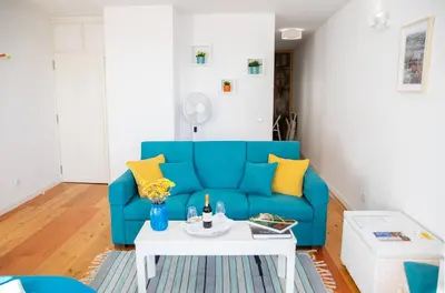 a living room with a blue couch and a table at Olival 54 Apartments in Porto