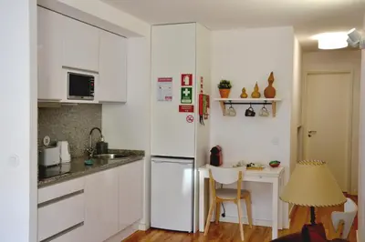 a kitchen with white cabinets and a white refrigerator at Olival 54 Apartments in Porto