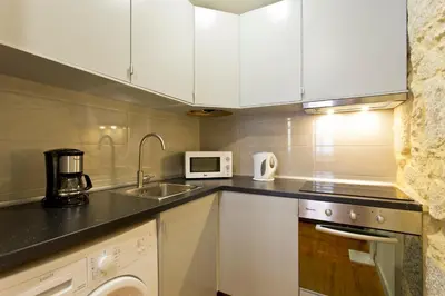 a kitchen with white cabinets and a sink at Casas de Vera Cruz in Porto