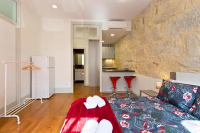 a living room with a couch and a stone wall at Casas de Vera Cruz in Porto