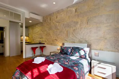 a bedroom with a bed and a stone wall at Casas de Vera Cruz in Porto