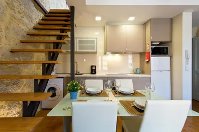 a kitchen with a table and chairs and a staircase at Casas de Vera Cruz in Porto
