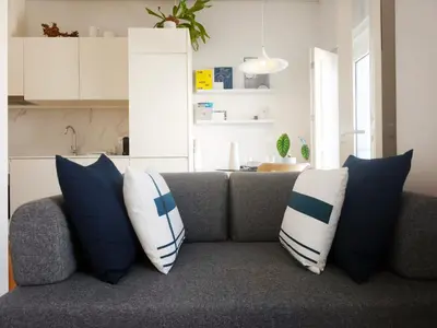 a couch with blue and white pillows on it at D858 - comfort near downtown - AC & balcony in Porto