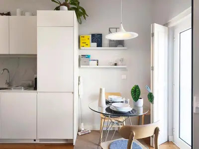 a kitchen with a table and a white cabinet at D858 - comfort near downtown - AC & balcony in Porto