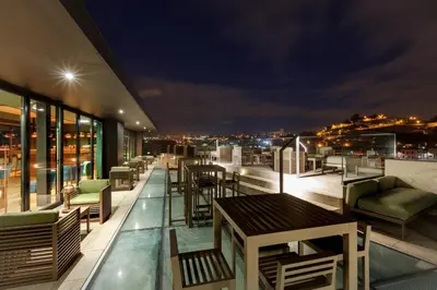 a balcony with tables and chairs on a building at NEYA Porto Hotel in Porto