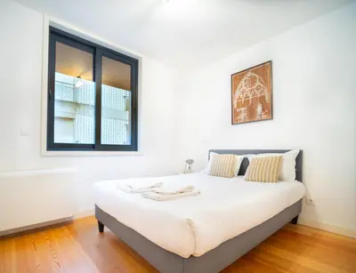 a bedroom with a large white bed with a window at Oporto City View - Alves da Veiga in Porto
