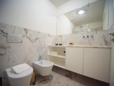 a white bathroom with a toilet and a sink at Oporto City View - Alves da Veiga in Porto