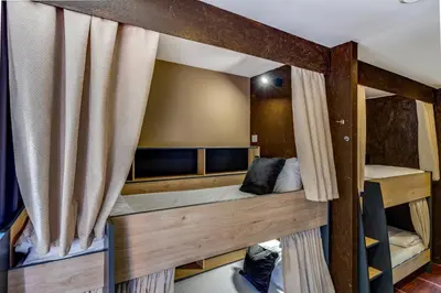 a room with two bunk beds with curtains at Garden in Town Hostel in Porto