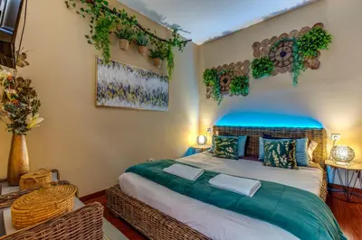 a bedroom with a large bed with plants on the wall at Garden in Town Hostel in Porto