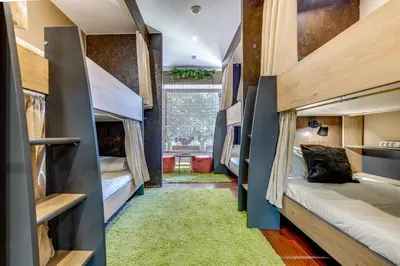 a room with bunk beds and a green rug at Garden in Town Hostel in Porto