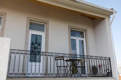 a white house with a balcony with windows at Oporto Down Town in Porto
