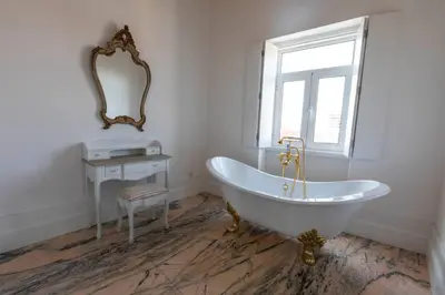 a bathroom with a tub and a window and a mirror at Oporto Down Town in Porto