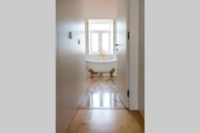 a white bathroom with a tub and a window at Oporto Down Town in Porto