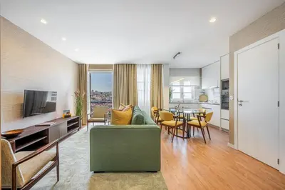 a living room with a blue couch and a flat screen tv at Casas do Porto - Ribeira Apartments in Porto