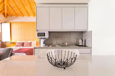 a kitchen with white cabinets and a counter top at Lemago Porto Apartments - São Bento in Porto