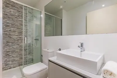 a bathroom with a sink and a toilet and a mirror at Lemago Porto Apartments - São Bento in Porto