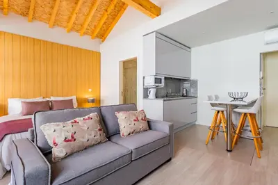 a living room with a couch and a kitchen at Lemago Porto Apartments - São Bento in Porto