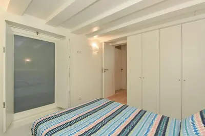 a white bedroom with a bed and a window at Duque - Guest House in Porto