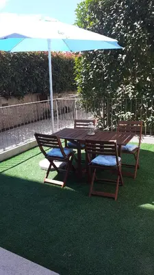 a wooden table with two chairs and an umbrella at Duque - Guest House in Porto
