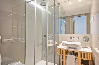a bathroom with a glass shower and a sink at Pur Oporto Boutique Hotel by actahotels in Porto