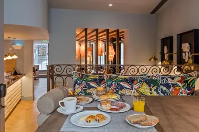 a lobby with chairs and plants on the ceilings at Pur Oporto Boutique Hotel by actahotels in Porto