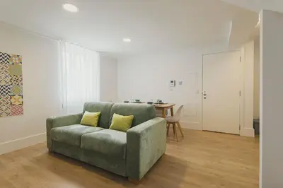 a living room with a green couch and a table at Vibrant Host - Heroismo's Metro in Porto